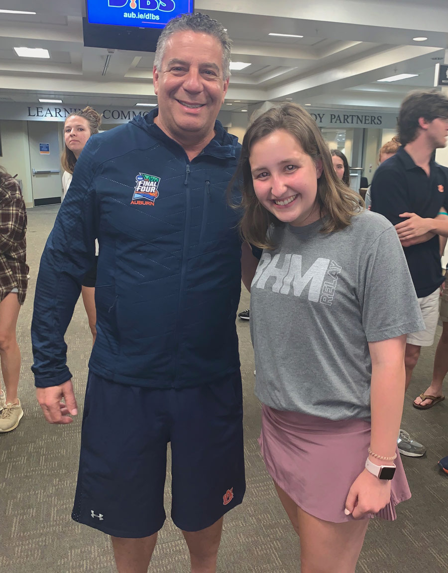 Charlotte Baker smiling while standing next to Auburn basketball coach Bruce Pearl.