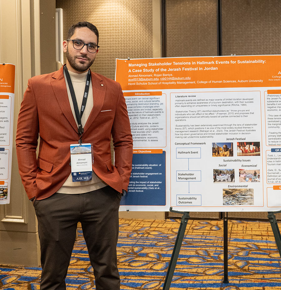 Student Ahmad Almomani standing by his research poster on event sustainability in Jordan.